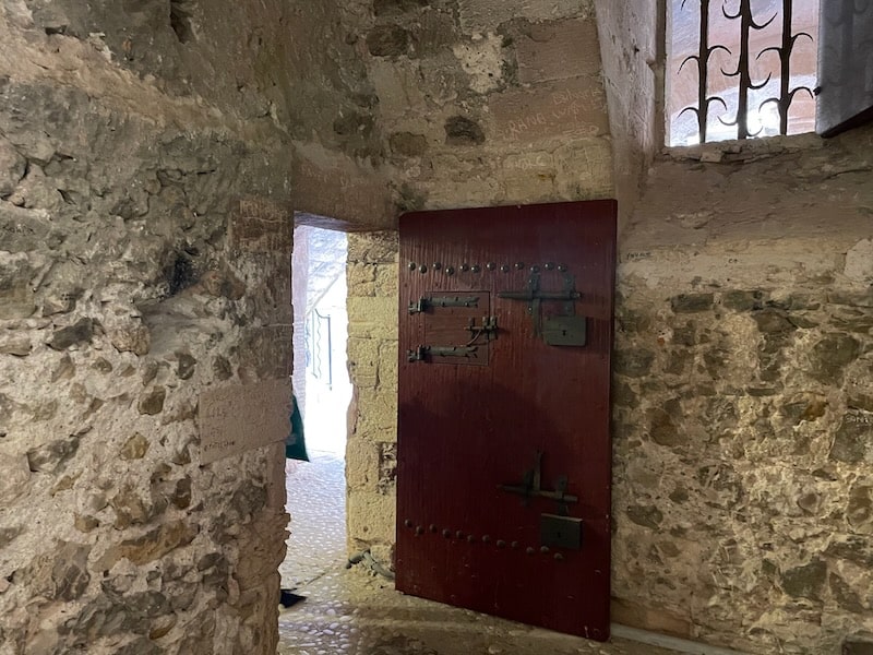 Stone walls of Chateau d'If cell bear graffiti, a testament to the lives of former inmates.