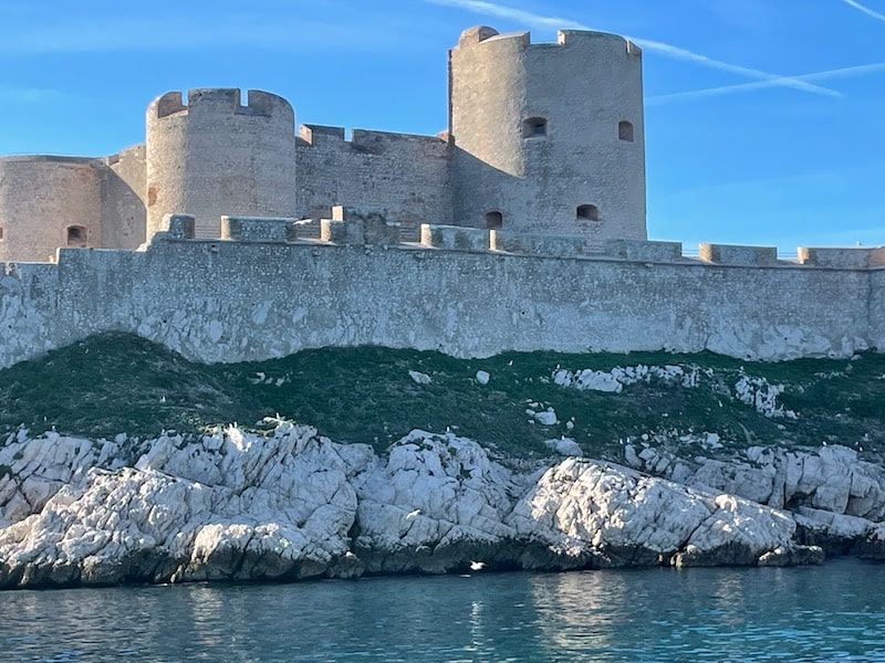 Approaching Chateau d'If's imposing cliffs by boat, Marseille, France.