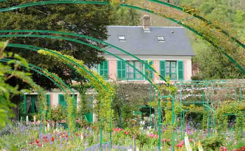 House and garden of Monet in Giverny, filled with greenery and colour on a day trip to Giverny from Paris