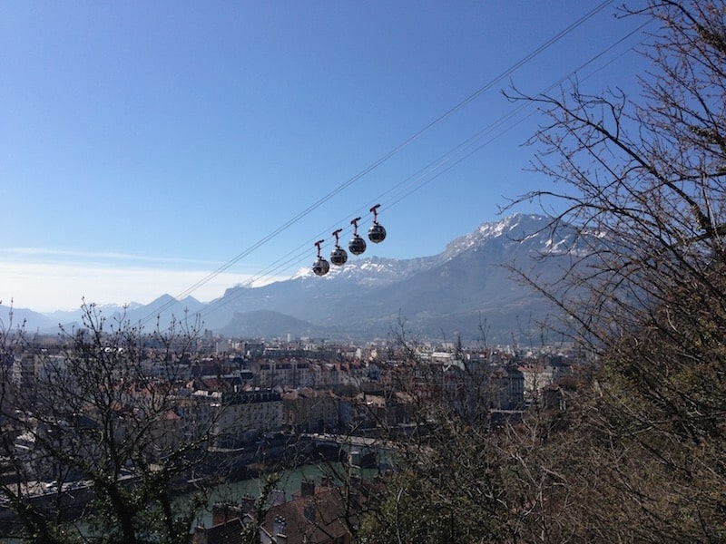Cable cars over Grenoble, France with French Alps in the background