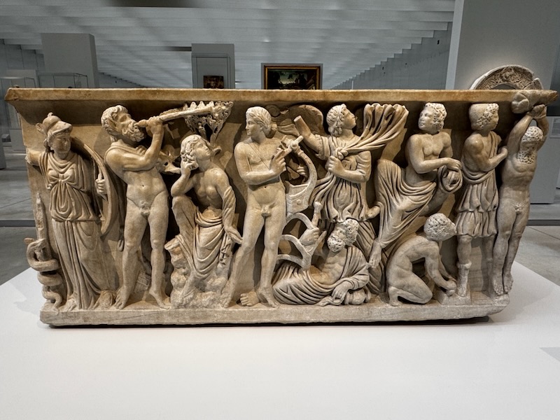 Roman marble sarcophagus depicting the mythological musical contest between Apollo and Marsyas, with figures gathered around the two contestants
