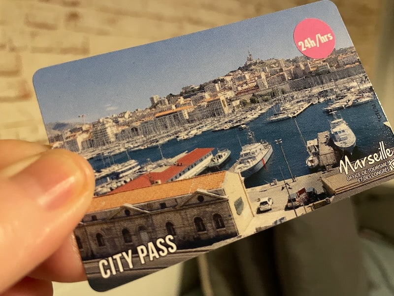 Hand holding a Marseille city pass.