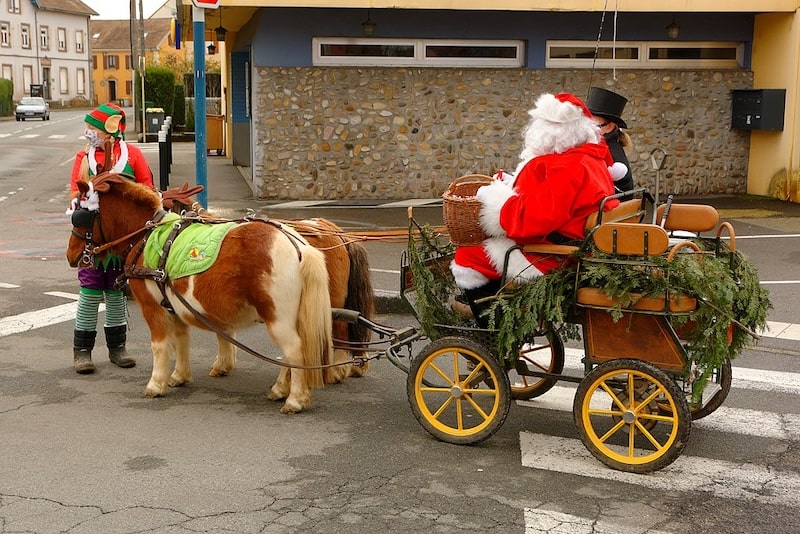 Father Christmas, or Santa Claus, in France, being pulled by horses in a cart Father Christmas, or Santa Claus, in France, being pulled by horses in a cart