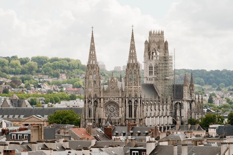 A view of the magnificent Rouen Cathedral from a distance, with the town around it